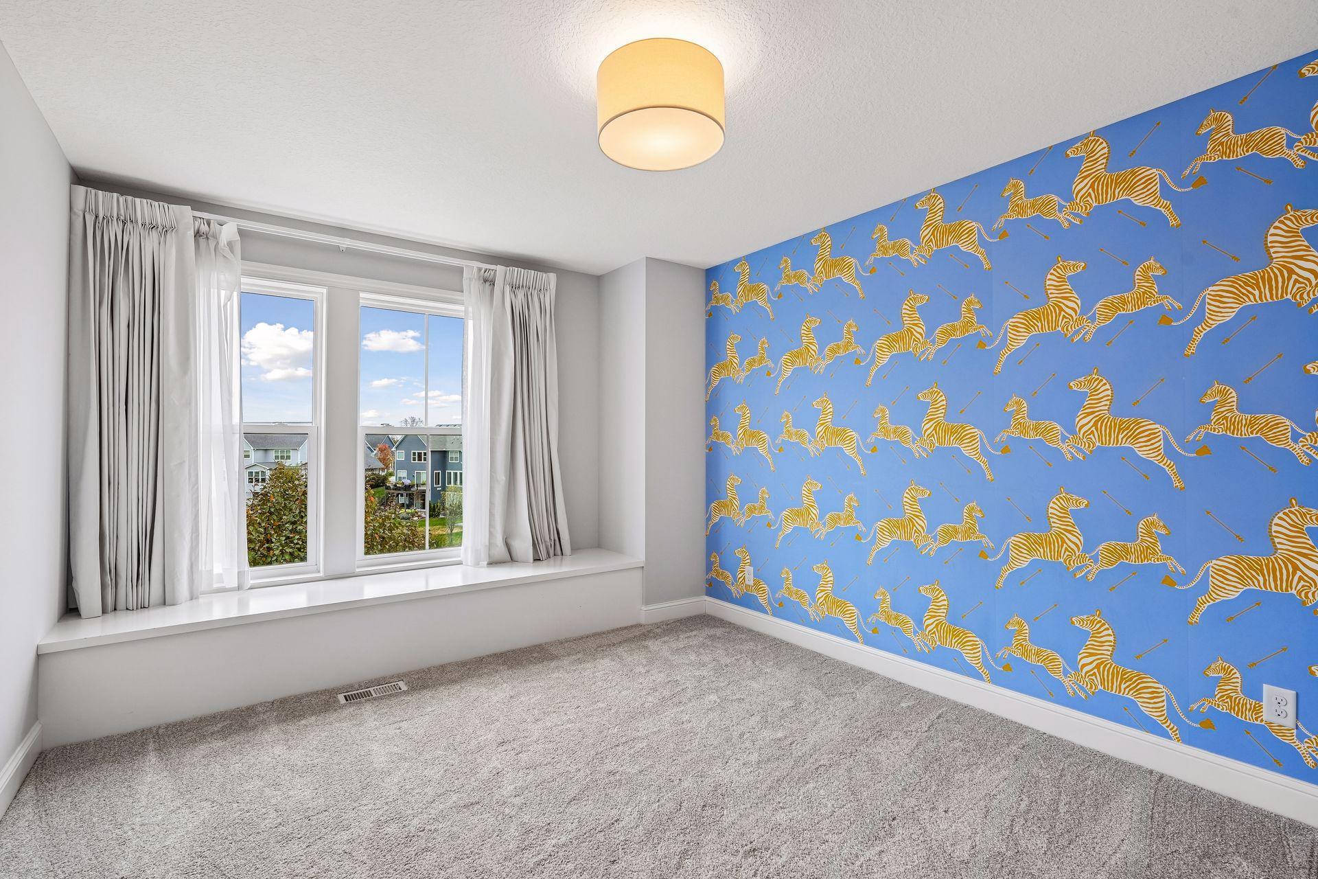A spacious upper-level bedroom with custom wallpaper and convenient access to a shared Jack-and-Jill bathroom.