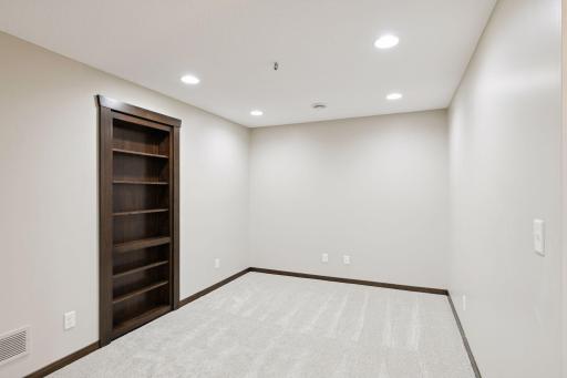 Custom built-in bookcases function as hidden doors, with this one leading to the mechanical room.