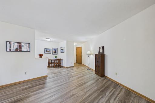 Spacious living room with updated flooring, neutral dÃ©cor, and an open layout that flows seamlessly into the dining area.