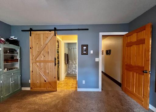 Primary Bedroom ensuite with Barn Door for function and style that leads to the Primary Bath and Walk in Closet.