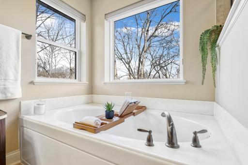 Relax and unwind in the spacious soaking tub surrounded by windows that fill the primary bath with natural light. A peaceful setting adds to the private, spa-like feel of the primary suite.