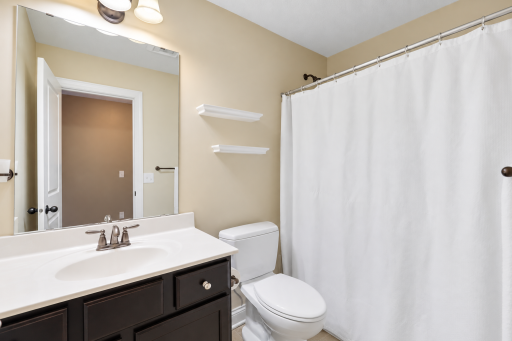 Upstairs full bathroom conveniently located just outside the fourth bedroom, featuring a spacious vanity, tub/shower combination, and clean neutral finishes.