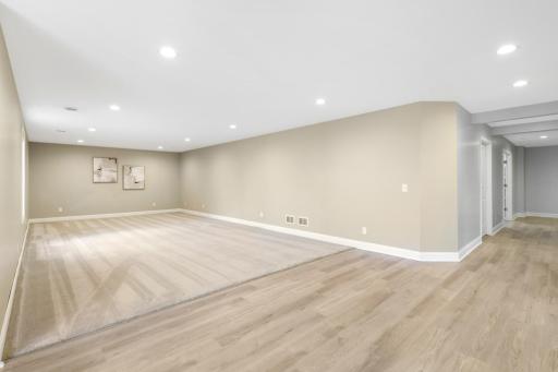 Spacious finished lower level offers an open, flexible layout with recessed lighting, a combination of carpet and durable flooring, and a walkout to the wooded backyard.