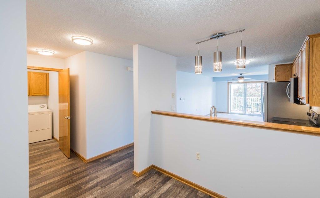 Dining room view of separate laundry room with upper cupboards for ample storage. There is also a coat closet near the main door.