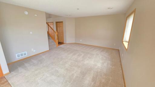 Spacious living room with newer carpet. Cord runs inside wall for entertainment purposes.