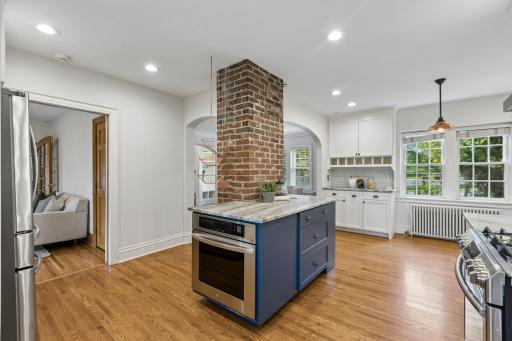 Spacious eat-in kitchen with exposed brick and blue center island