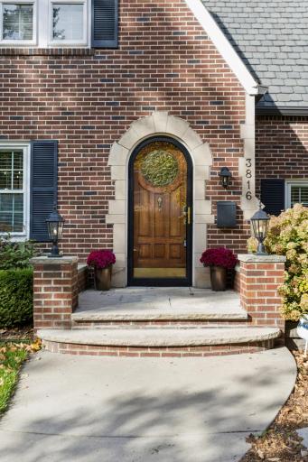 Arched front door and brick steps welcome you home