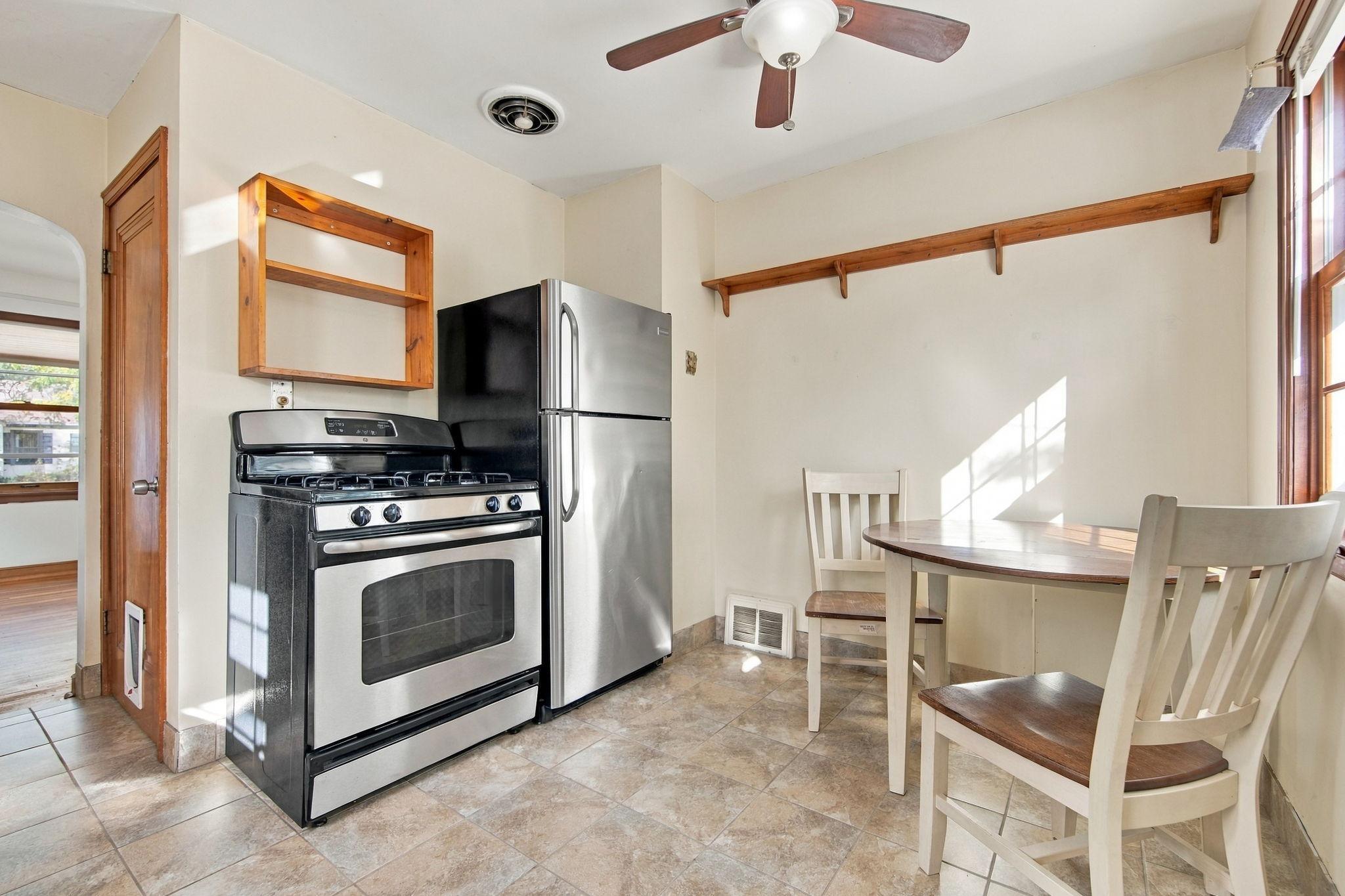 The bright, sun-filled kitchen features stainless steel appliances.