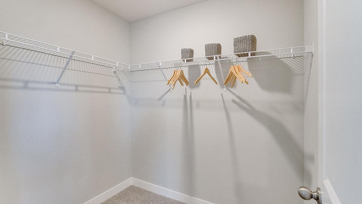 Large walk-in closet in the secondary bedroom. *Photo is of a model home, colors may vary in actual home.
