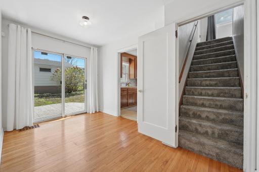Carpeted staircase to upper level (new 2025) â kitchen and patio at left and right