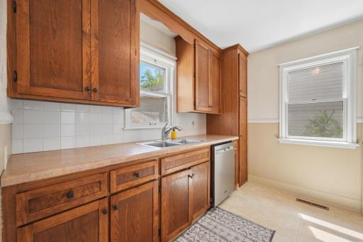 White subway tile backsplash with warm wood cabinetry and abundant counter space