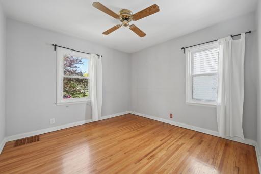 Main floor primary bedroom with hardwoods and dual-aspect natural light