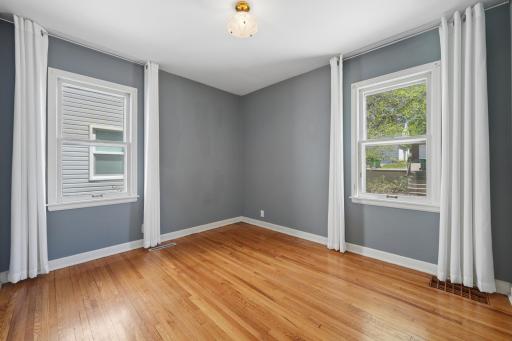 Second main floor bedroom â gray walls, hardwood floors, two windows