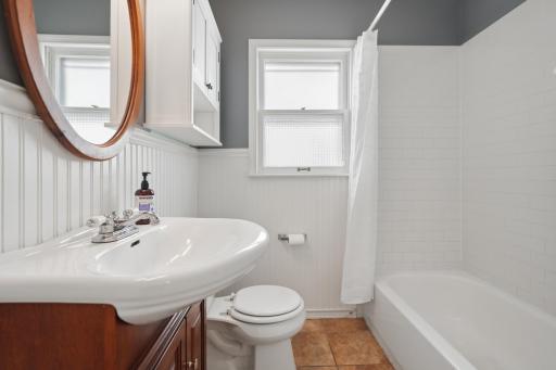 Main floor full bath â beadboard wainscoting, oval vanity, classic subway tile tub surround