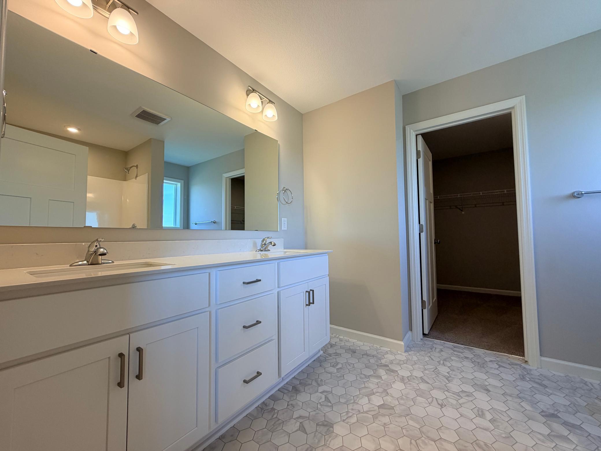 Dual vanity primary bath with ample cabinet storage.