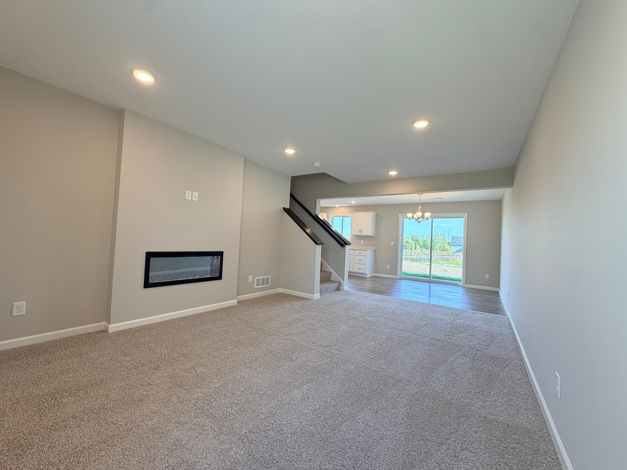Living room anchored by electric fireplace, perfect for ambiance or warmth!