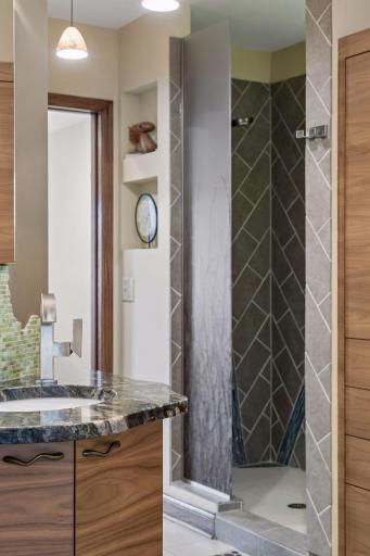 Primary bath walk-in shower with patterned tile and built-in niche.