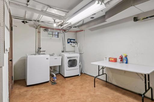 Lower-level laundry with utility sink and open work space.