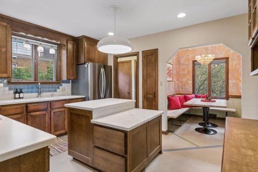 Kitchen with wood cabinetry, pendant lighting, and view into the breakfast nook.