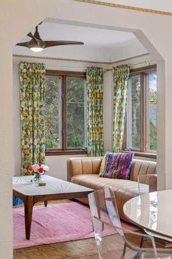 Sunroom with tall oak-trimmed windows overlooking mature trees.