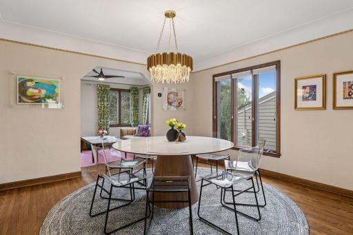 Formal dining room with rope-trim plaster crown, oak floors, and opening to the sunroom.