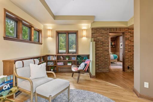 Wellness room library lounge with built-in bookcases, wood floors, and exposed brick wall.