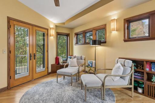 Wellness room lounge with vaulted ceiling, built-in bookcases, and French doors to the front balcony.