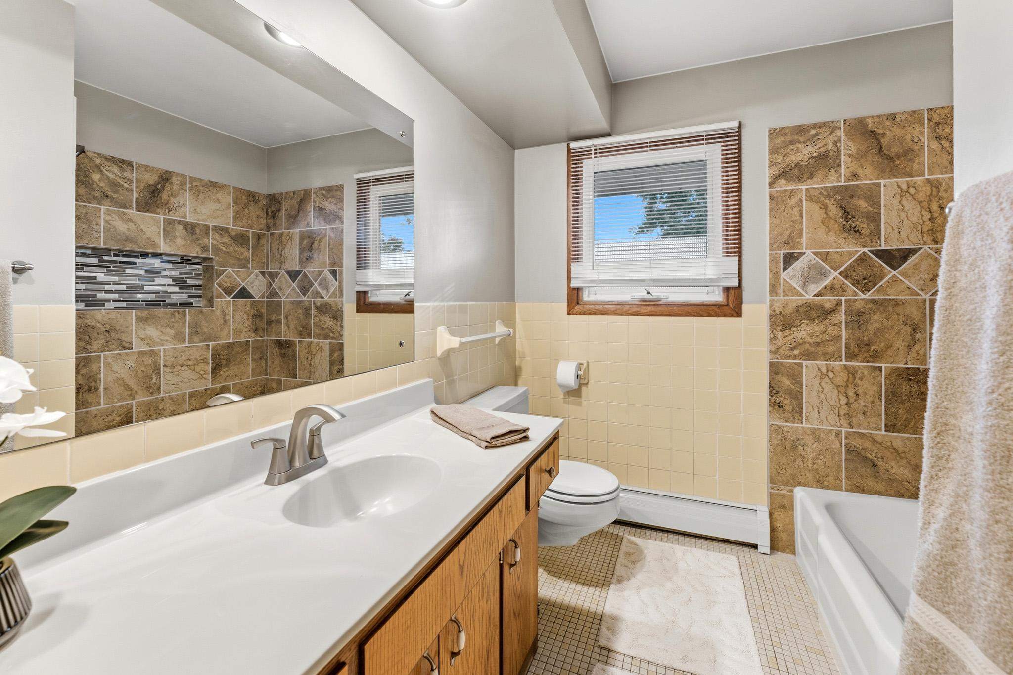 Full Main Floor Bath featuring new tiled surround and new plumbing fixtures.