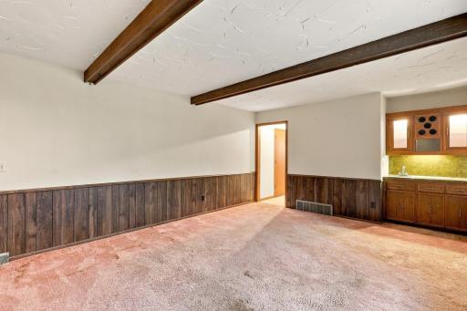 A versatile family room with a fireplace and wet bar offers plenty of possibilities.