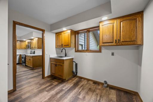 The spacious laundry room offers a sink, a window for natural light, and plenty of storage.