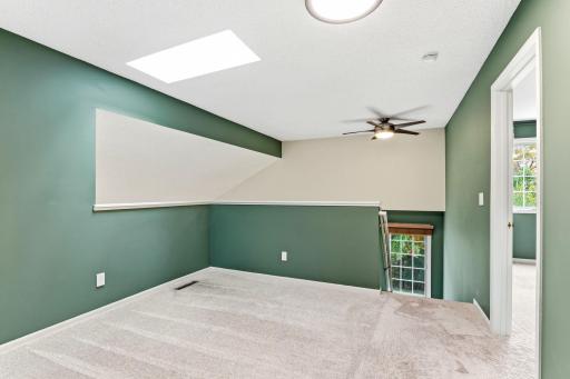 Head upstairs to a versatile loft space bathed in natural light from a bright skylight. This flexible area features plush carpeting and professional paint, perfect for a home office or cozy reading nook.