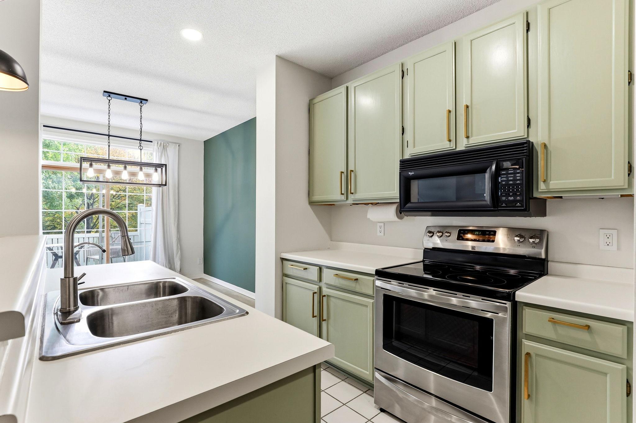 A double sink and expansive countertops offer excellent prep space. The kitchen overlooks the dining area, ensuring a connected and functional layout.