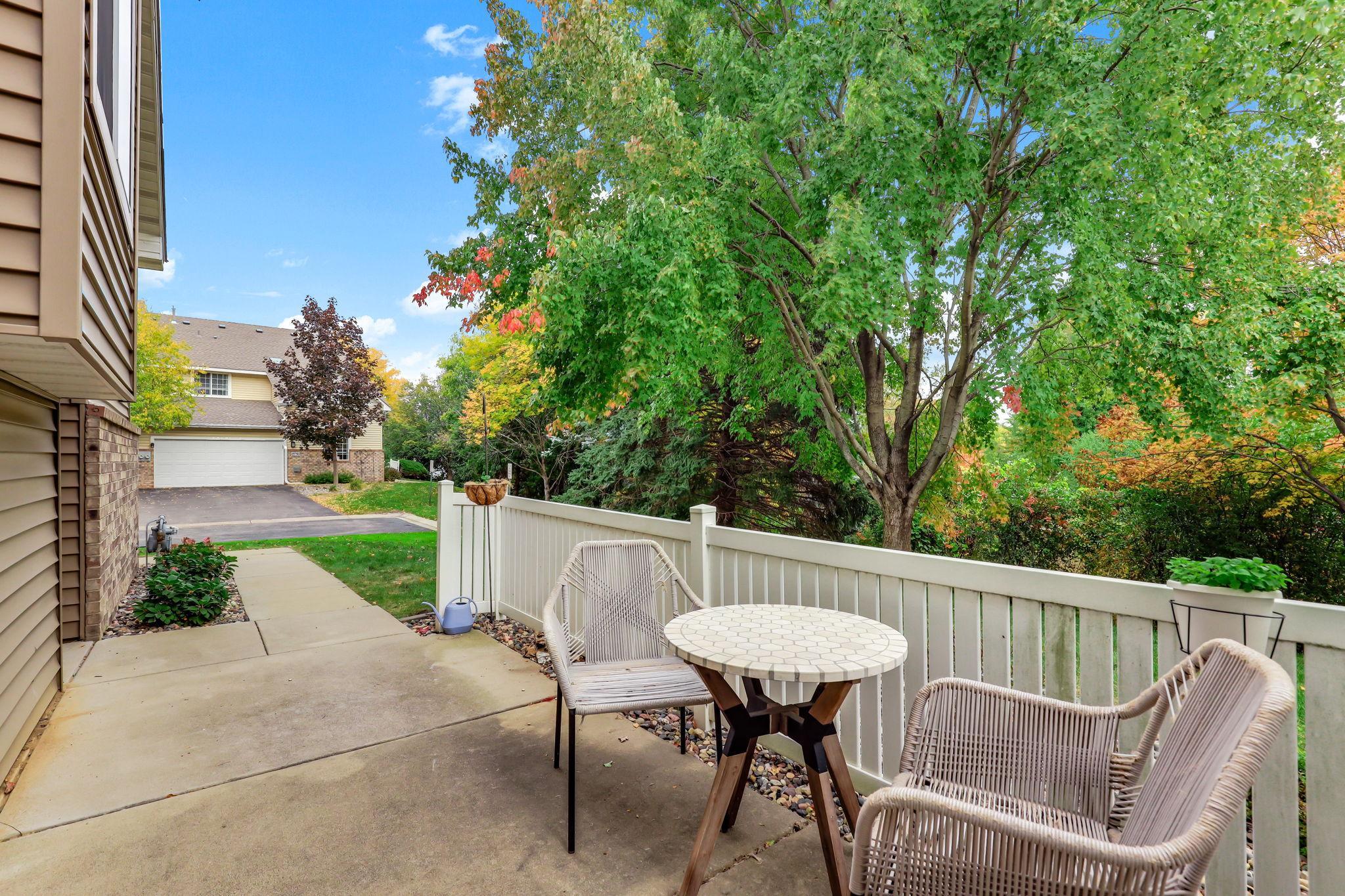 Looking out from the patio, the space connects seamlessly to the paved walkway and driveway. Enjoy peaceful neighborhood views framed by beautiful shade trees right outside your quiet end-unit townhome retreat.