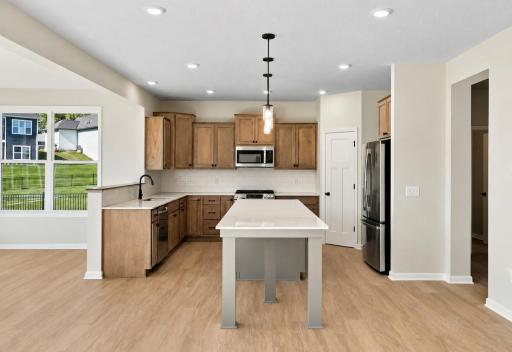 Photo for 1185 Oakwood Lane S, Delano, MN 55328 - listing #7158450 Warm and inviting kitchen featuring ample cabinetry and a spacious center island! *Model home photos, colors and selections may vary.*