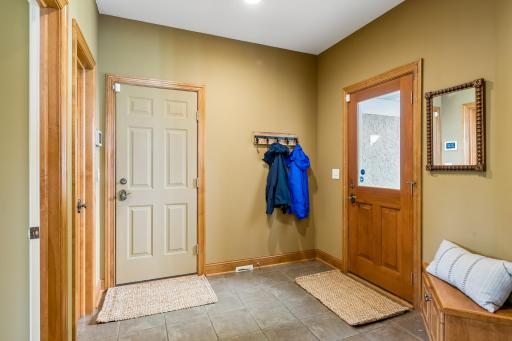 Tiled mudroom with coat closet off the garage