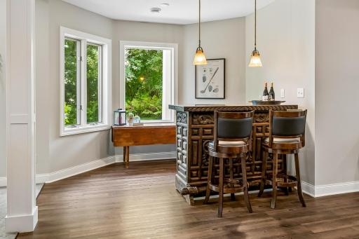 Convenient bar area for libation and conversation with designer pennant lighting
