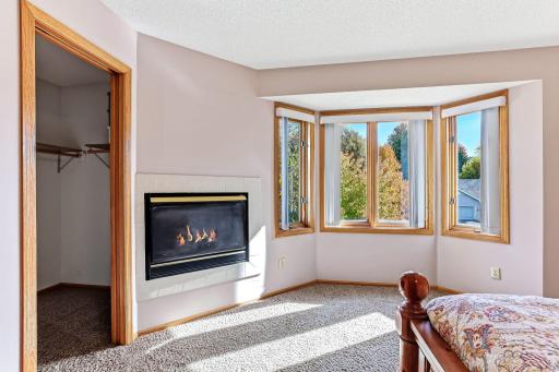 Primary suite featuring a gas fireplace and a beautiful bay window that adds warmth, light, and architectural charm.