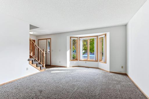 Living room highlighted by a beautiful bay window that fills the space with natural light.