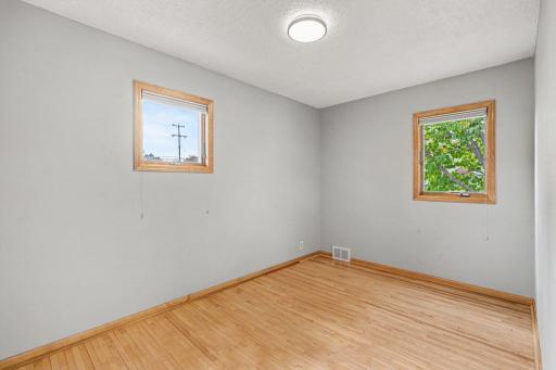 SECONDARY BEDROOM HAS REAL WOOD MAPLE FLOOR, NEWER LIGHTING, FRESH PAINT AND PANELED DOORS