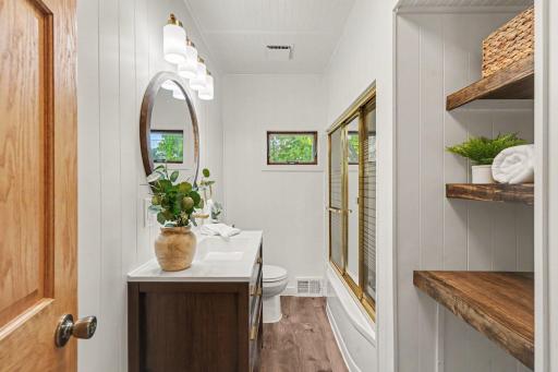 LVP FLOOR, PANELED DOOR, OPEN SHELVING AND COMBO TUB AND SHOWER