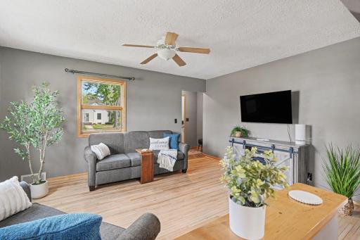WELCOMING LIVING ROOM WITH REAL MAPLE WOOD FLOORS, CEILING FAN AND NEW PAINT