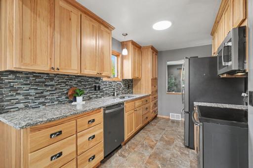 BEAUTIFUL HICKORY CABINETS WITH SOFT CLOSE HARDWARE, STACKS OF DRAWERS, GRANITE COUNTERTOPS AND GLASS AND TILE BACKSPLASH