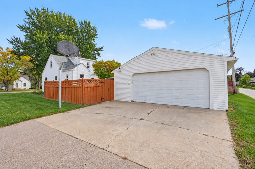 OVERSIZED TWO CAR GARAGE WITH CONCRETE DRIVEWAY AND BASKETBALL HOOP