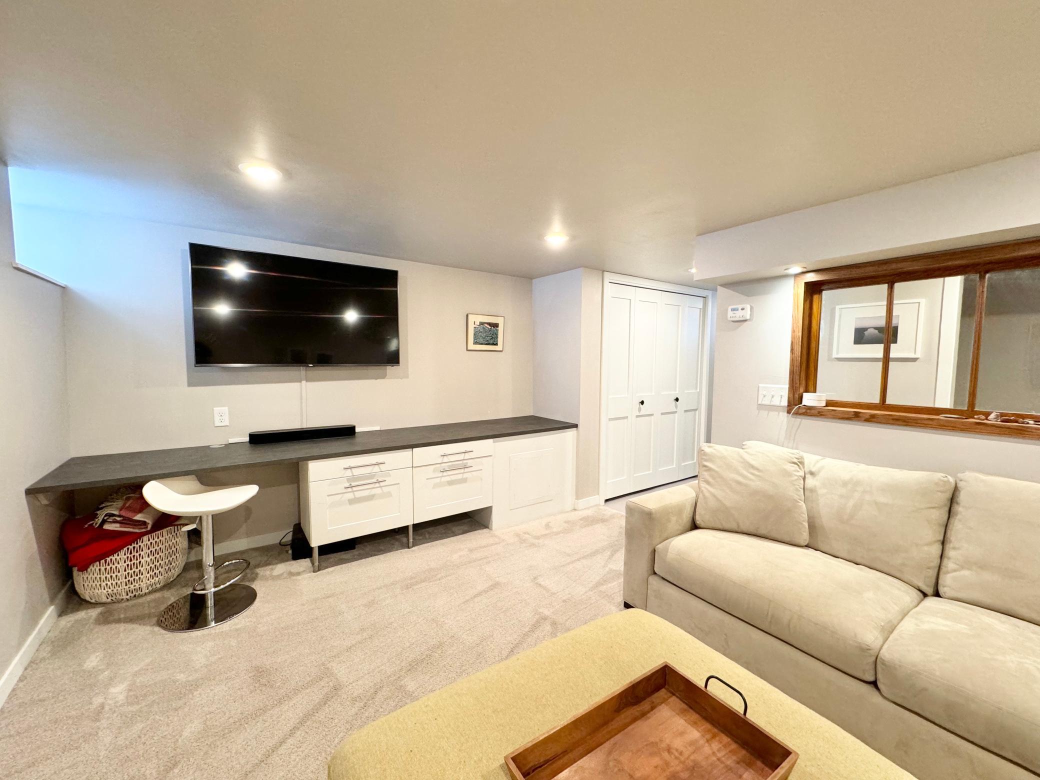 Entertainment room has a built in desk.