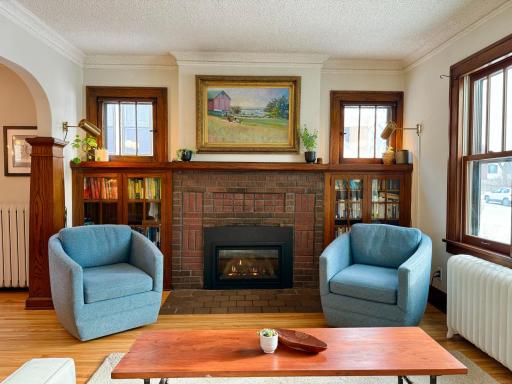 Cozy gas fireplace with brick surround and built-ins.