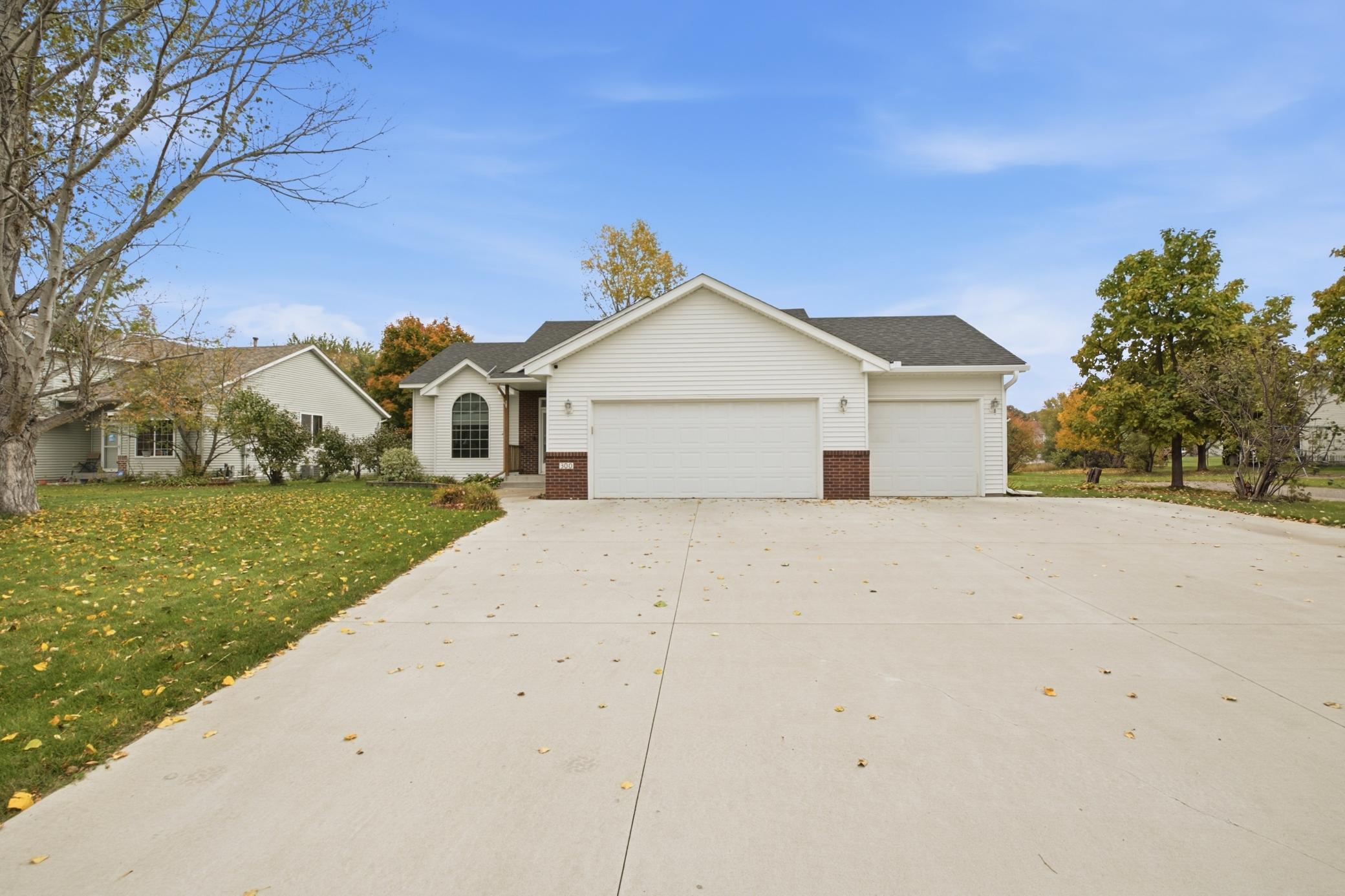 A covered front entry, full-glass storm door, and transom window above the front door create a welcoming first impression, while the new concrete driveway, completed in 2024, adds to the home’s curb appeal.