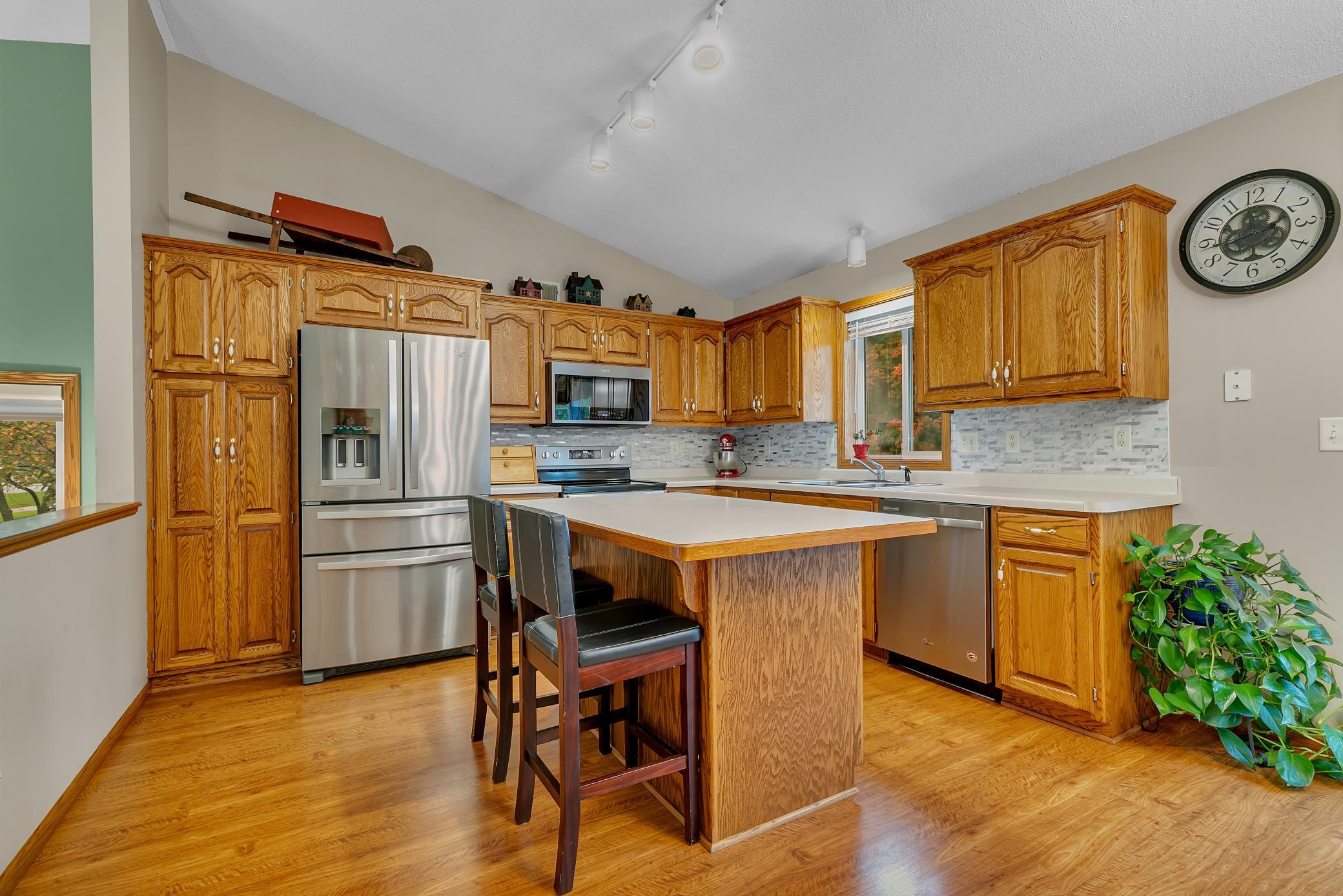 The kitchen features cathedral-style raised oak cabinetry and stainless steel appliances. The refrigerator, stove, microwave, and dishwasher have all been replaced within the past 10 years.