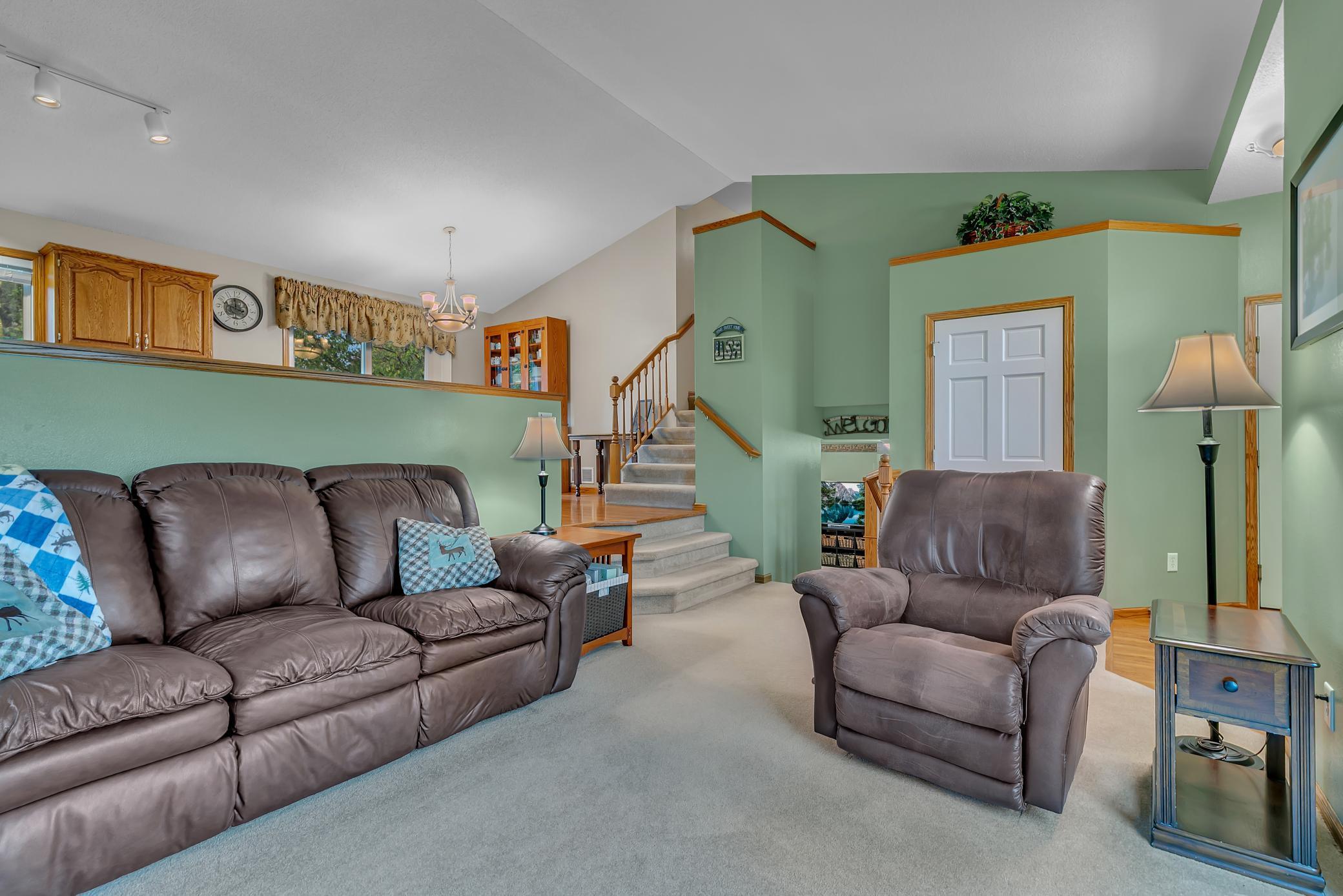 It’s an open and airy main living area with vaulted ceilings extending throughout the living room, kitchen, and dining room.