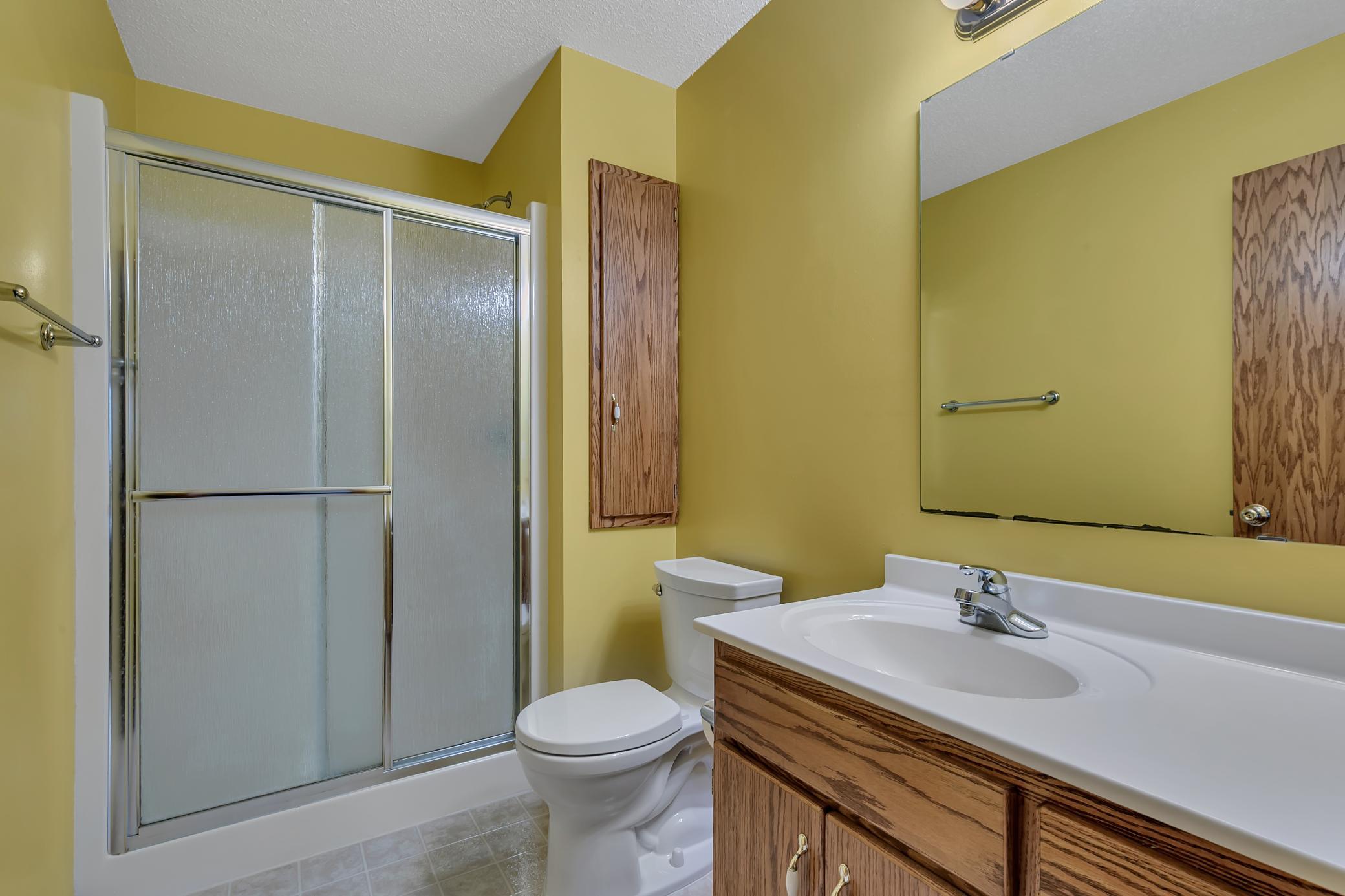 It’s a private three-quarter bathroom with a sit-down shower and built-in linen cabinet.