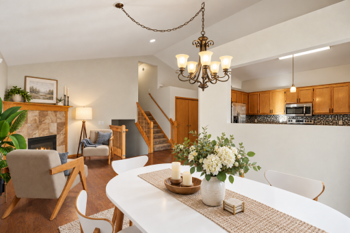 Virtually staged main-level living room showing the vaulted ceiling, hardwood floors, and gas fireplace.